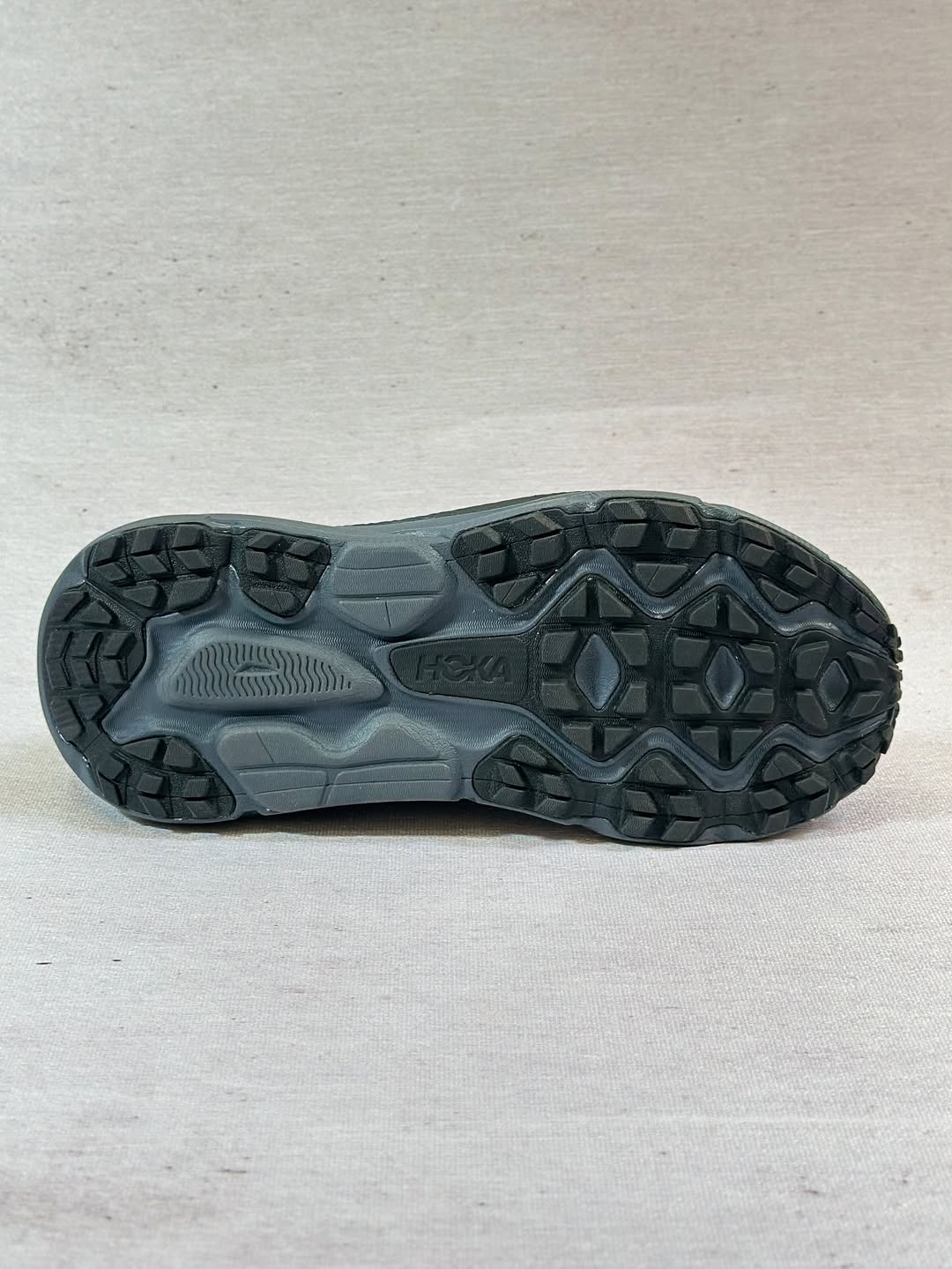 نمای کناری کفش هوکا چلنجر ATR 7 با رنگ خاکستری و جزئیات قرمز